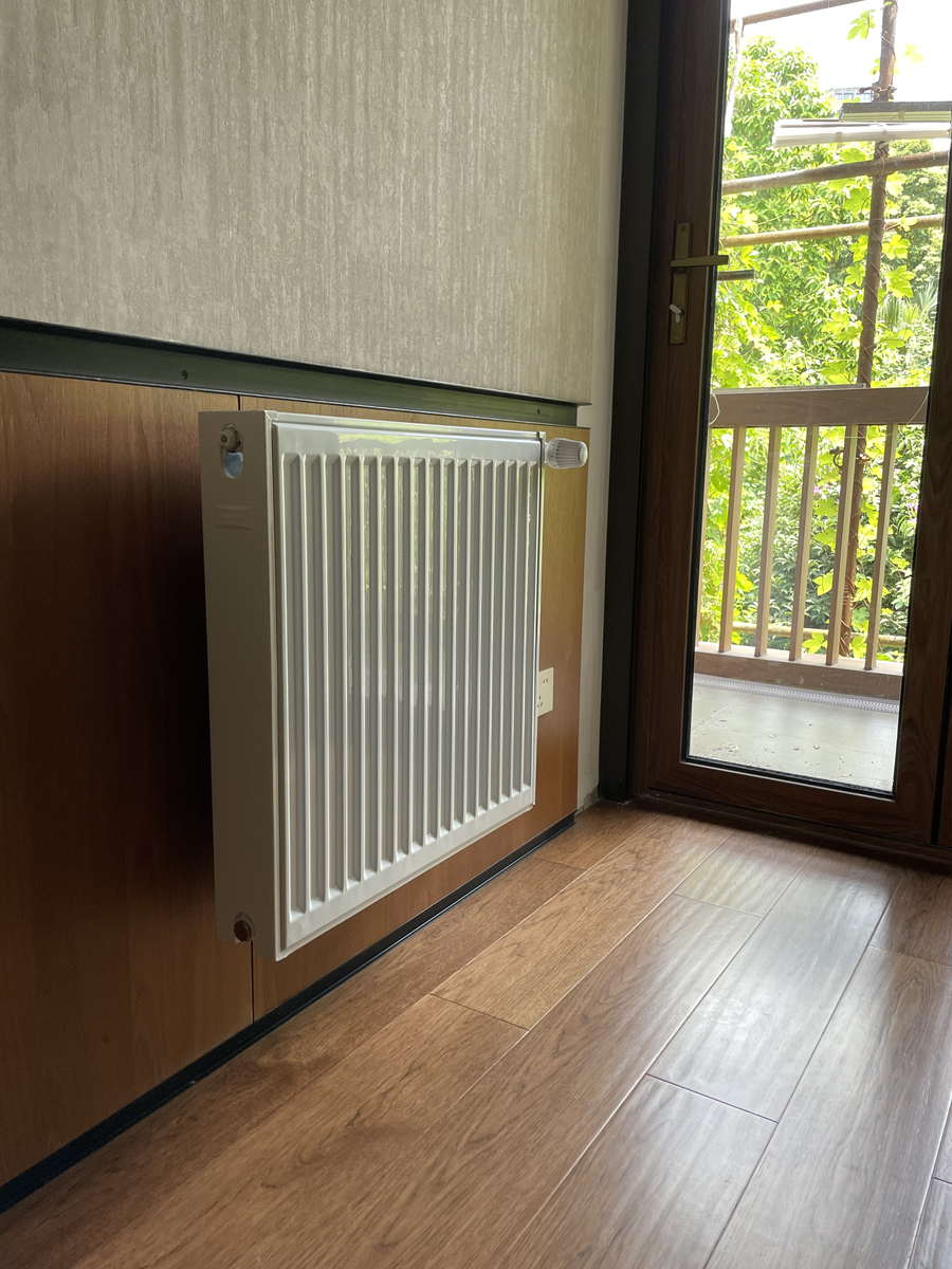 校内家属区房间墙面明装的钢制板式散热器