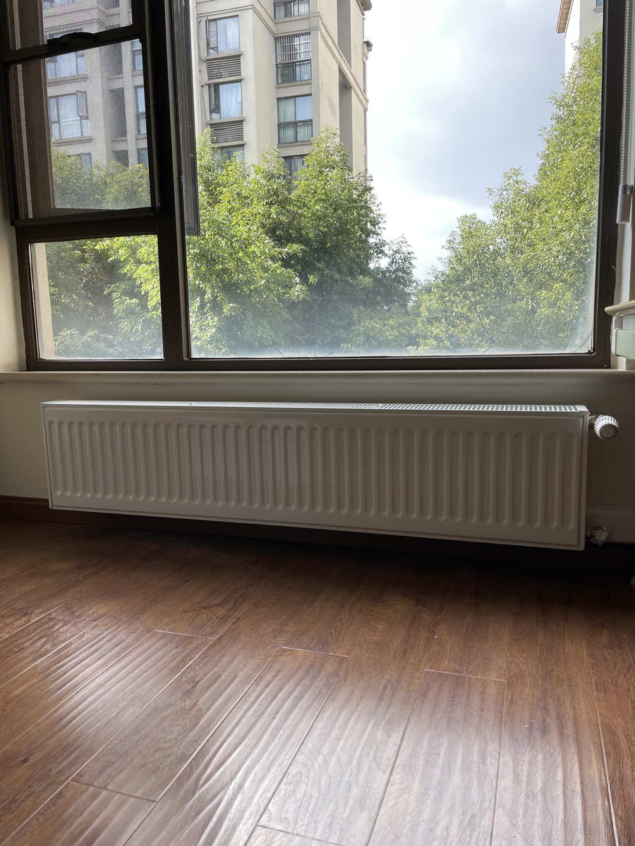北向房间窗下明装挂装的钢制板式散热器